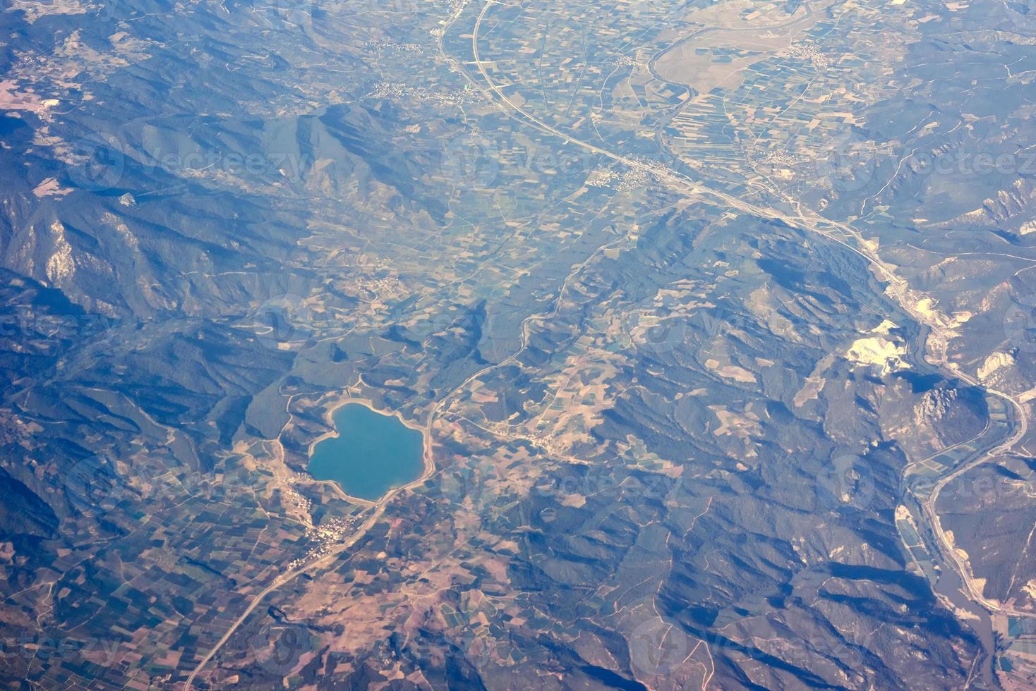 View from airplane, city in a mountain and coast photo
