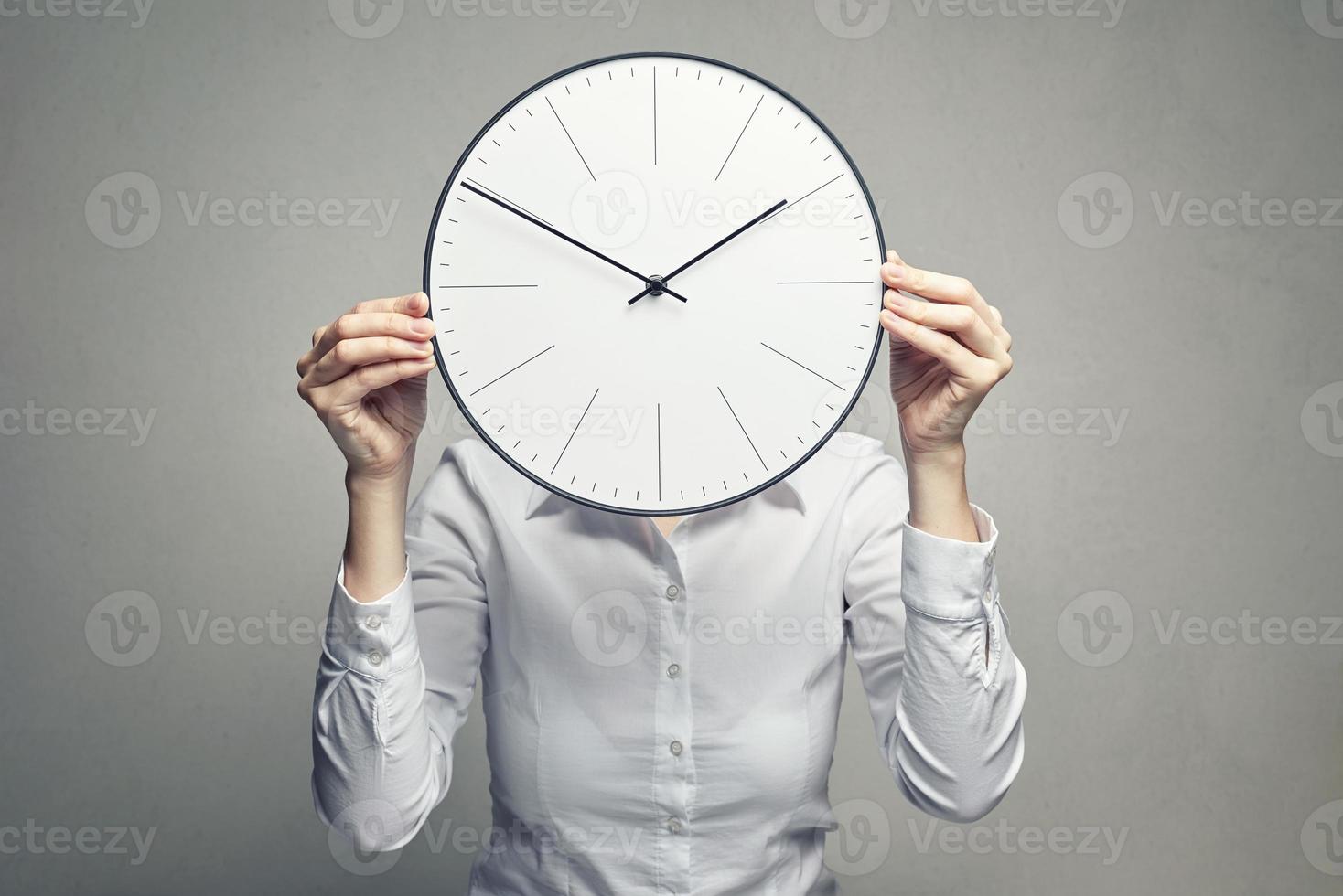 business woman covering her face with clock photo