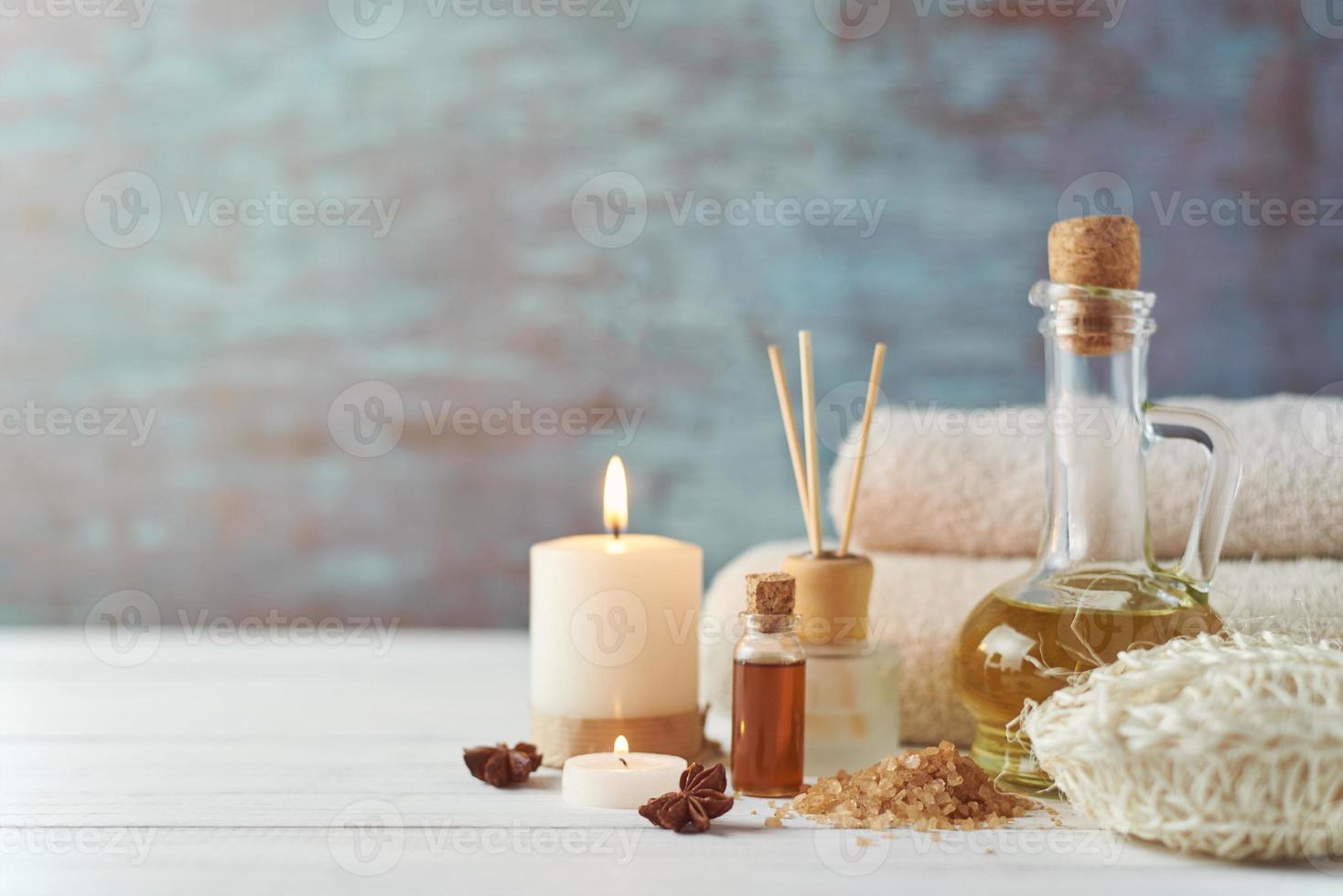 Towels, candle and massage oil on white table photo