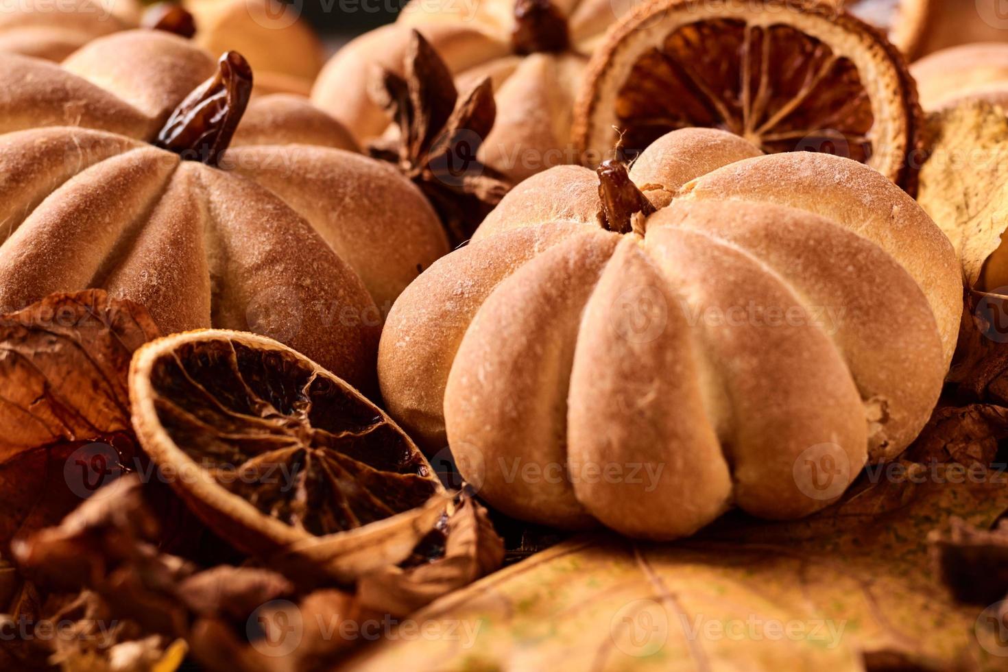 galletas caseras en forma de calabaza en hojas de otoño. foto