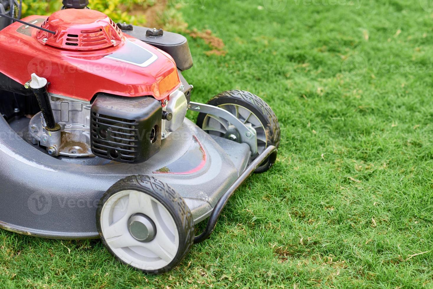 Lawn mover on green grass in a garden close up photo