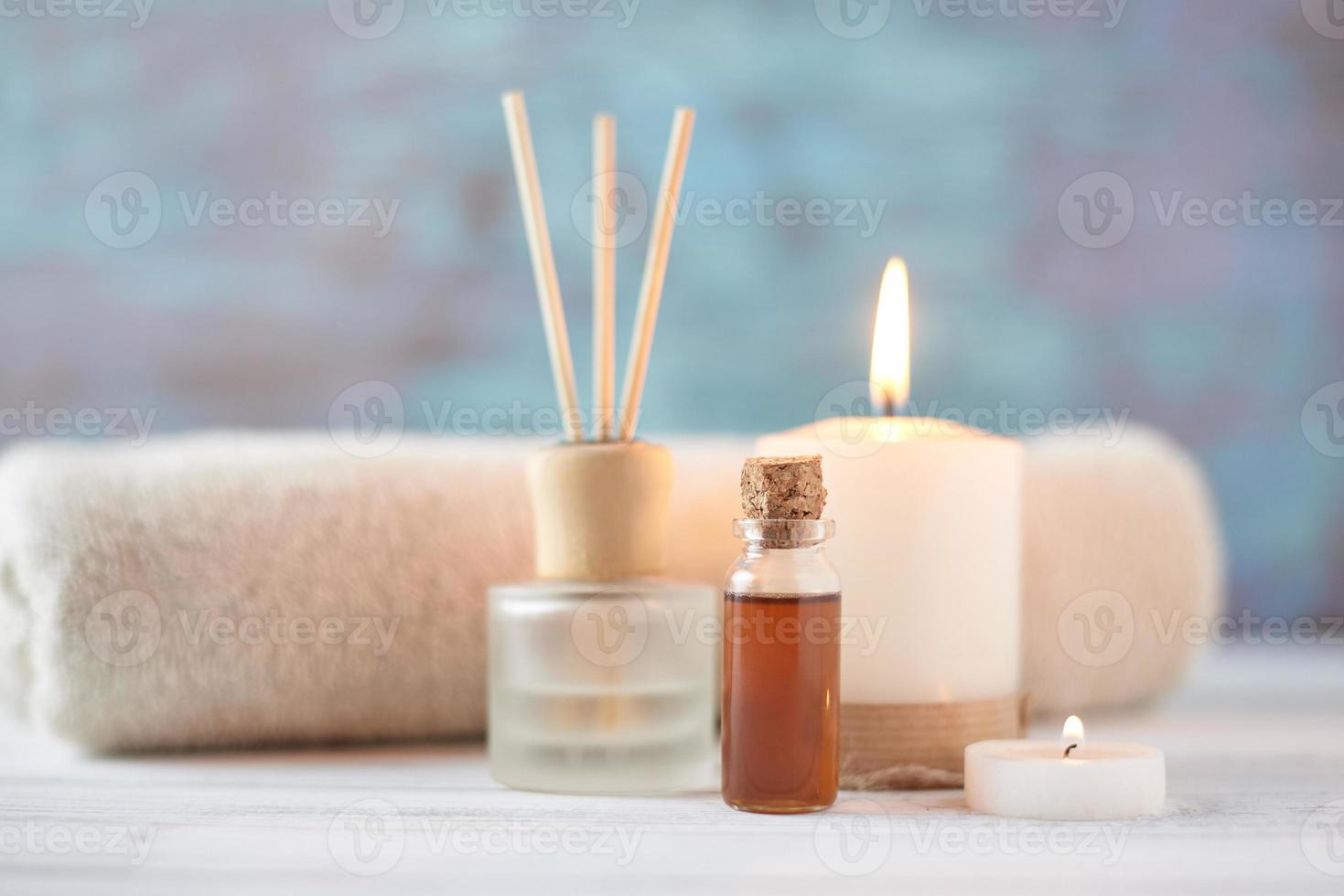 Towels, candle and massage oil on white table photo