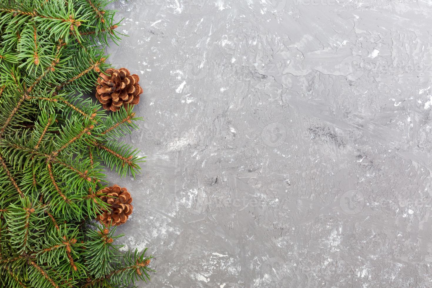 Christmas gray cement wooden background with fir tree frame and cones copy space. top view empty space for your design photo