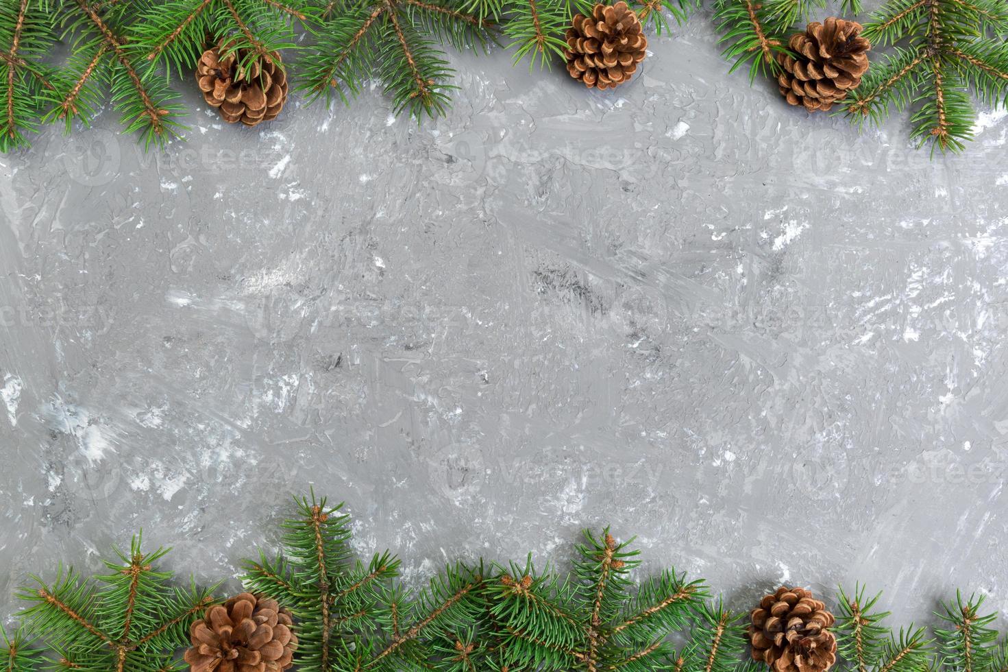 Christmas gray cement wooden background with fir tree frame and cones copy space. top view empty space for your design photo