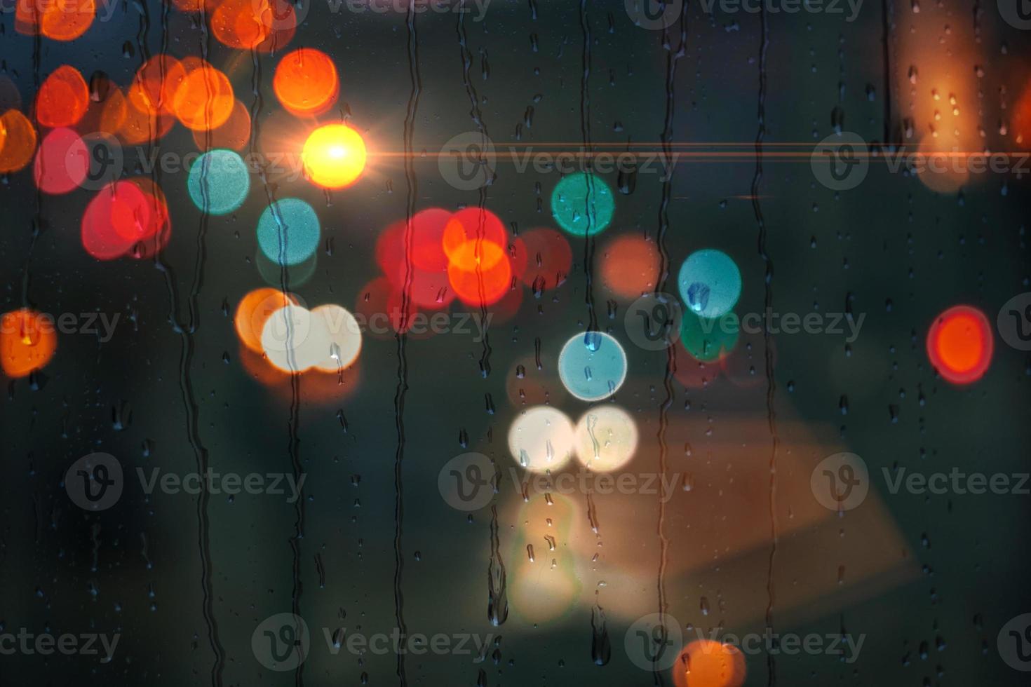 raindrops on the window in rainy days and street lights background photo