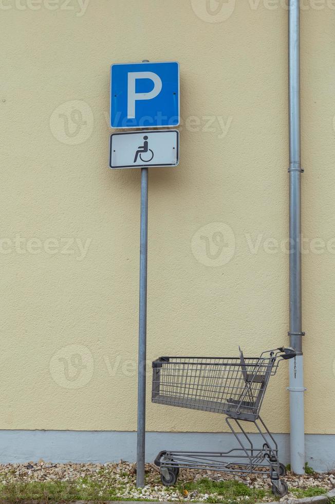 shopping cart in front of a parking sign photo