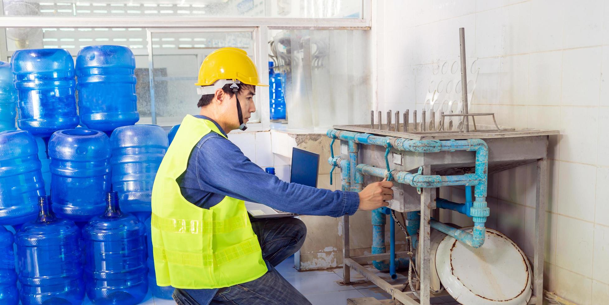 ingeniero que trabaja en una fábrica de agua potable usando una tableta para revisar y reparar el agua de la caldera en el sistema de agua en la fábrica foto