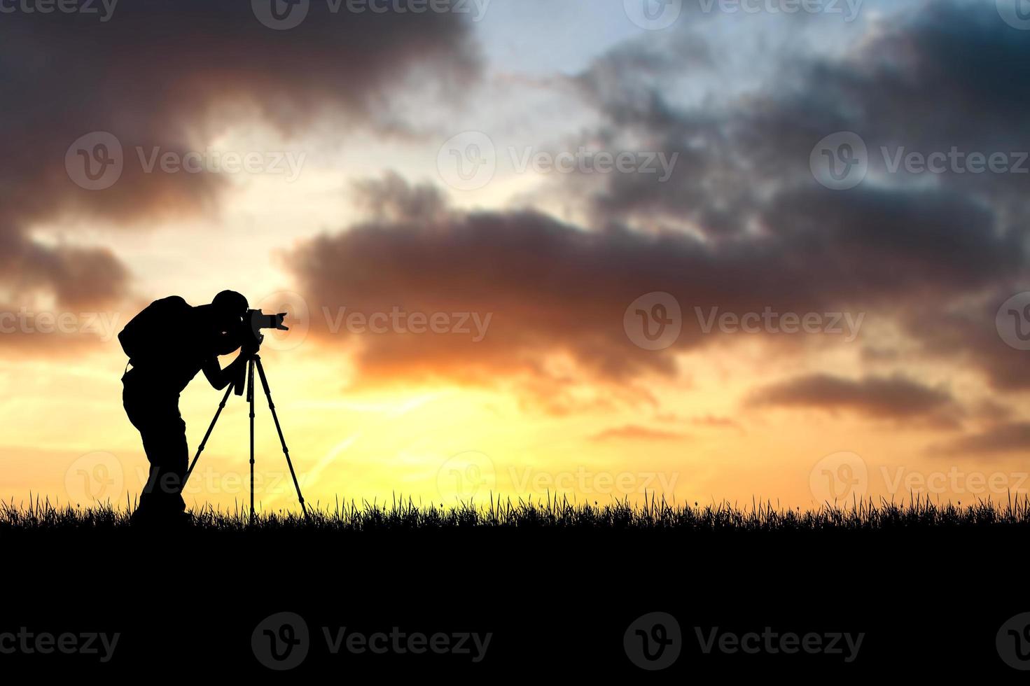 fotógrafo profesional tomando fotografías con cámara y trípode en un hermoso prado. foto