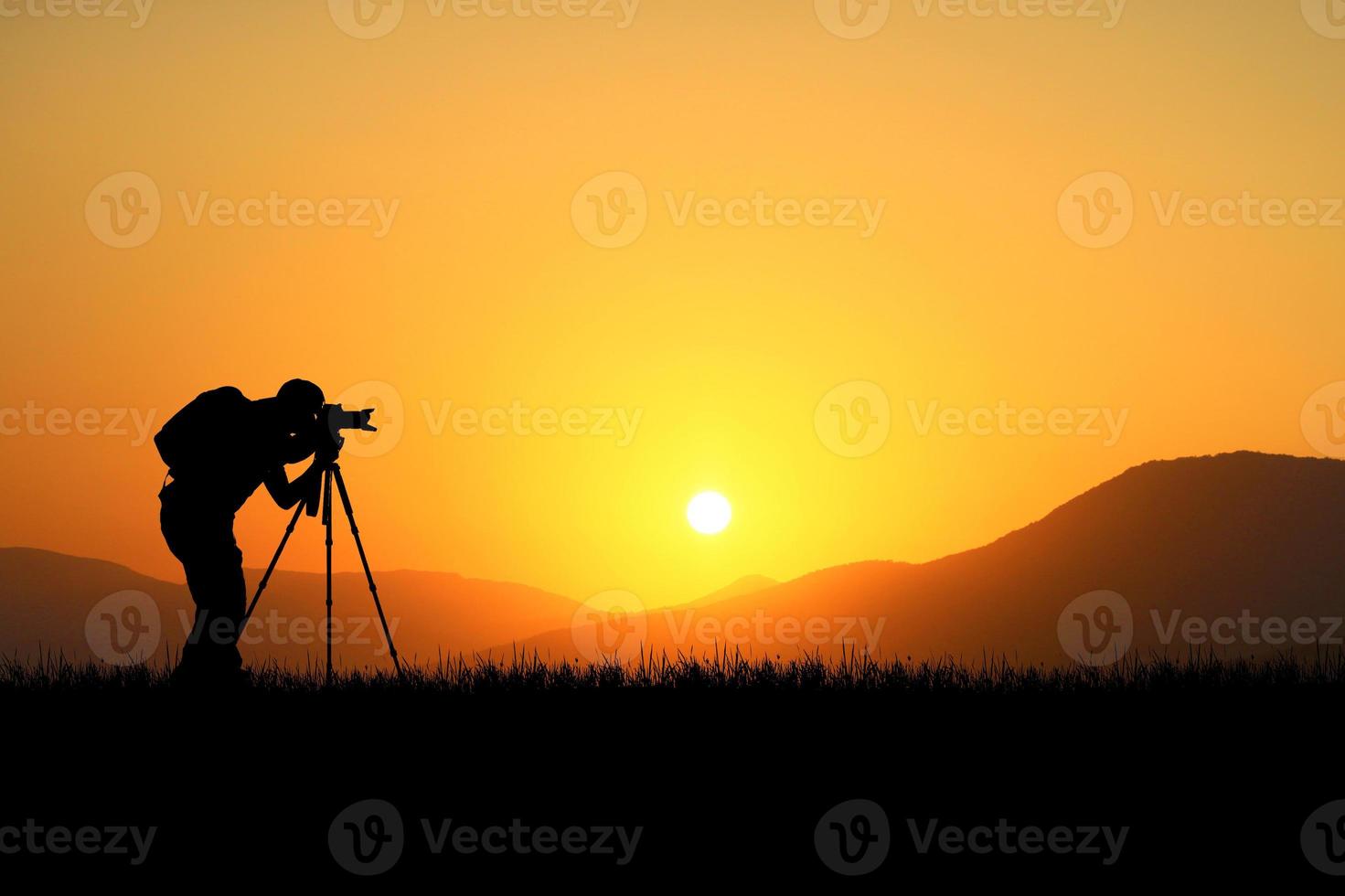 fotógrafo profesional tomando fotografías con cámara y trípode en un hermoso prado. foto