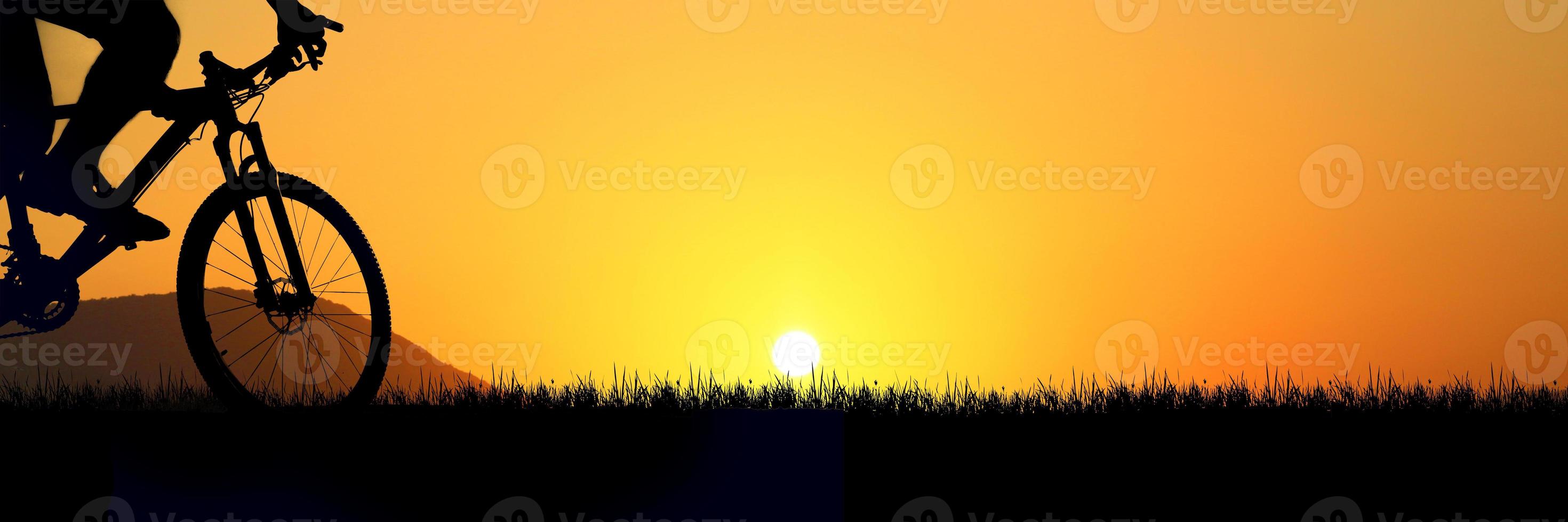 Silhouette of a happy cyclist in the meadow. Fitness and Travel Ideas photo