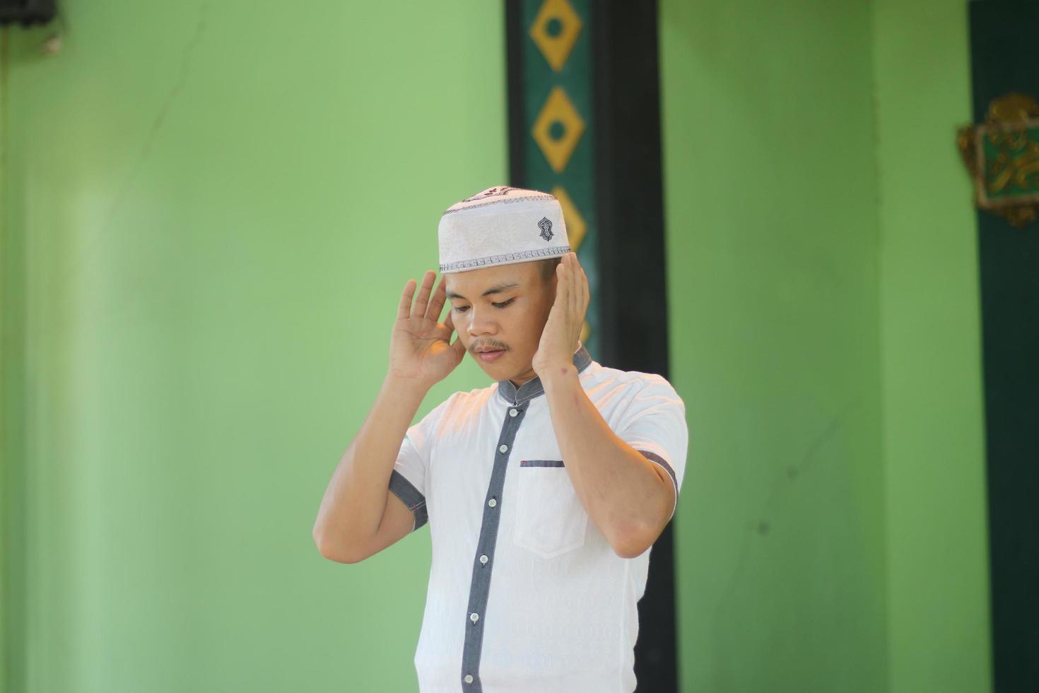 Young asian muslim praying in the mosque photo