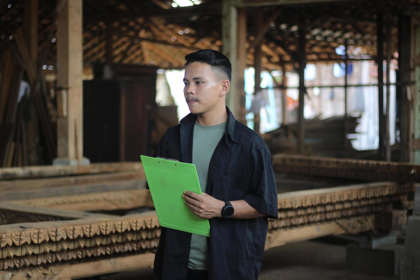 ASIAN YOUNG MAN BOSS OF WOOD COMPANY IS CHECKING QUALITY photo