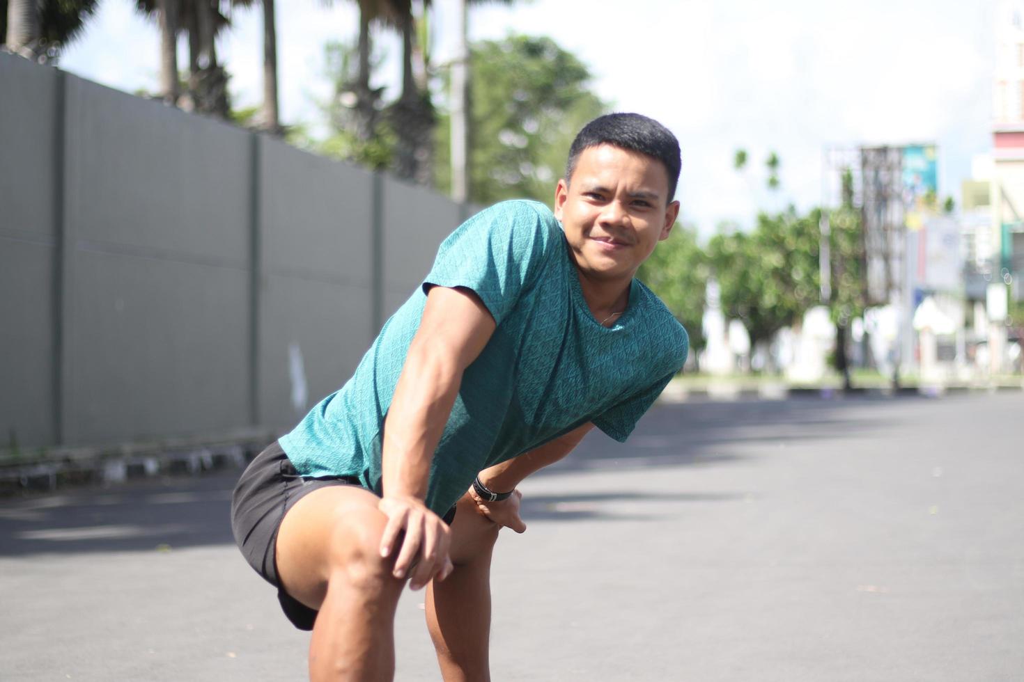 Young asian boy warming up for jogging in the morning photo