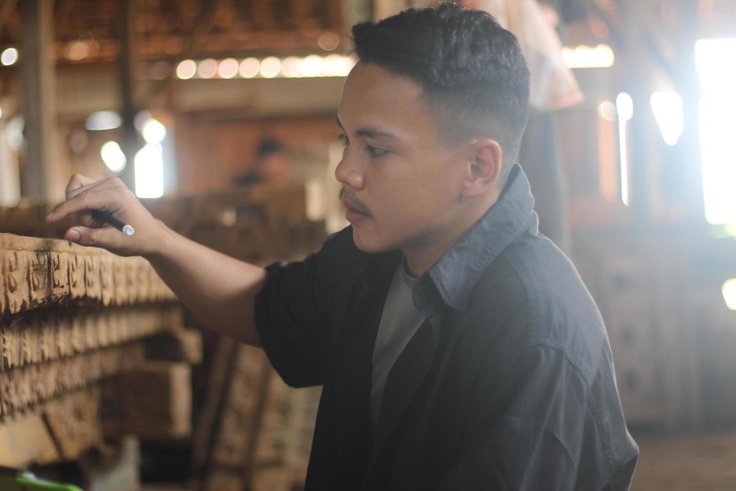 ASIAN YOUNG MAN BOSS OF WOOD COMPANY IS CHECKING QUALITY photo