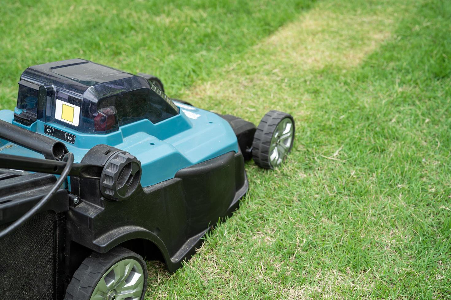 máquina de mover el césped cortó la hierba verde, hobby plantar el jardín de su casa. foto