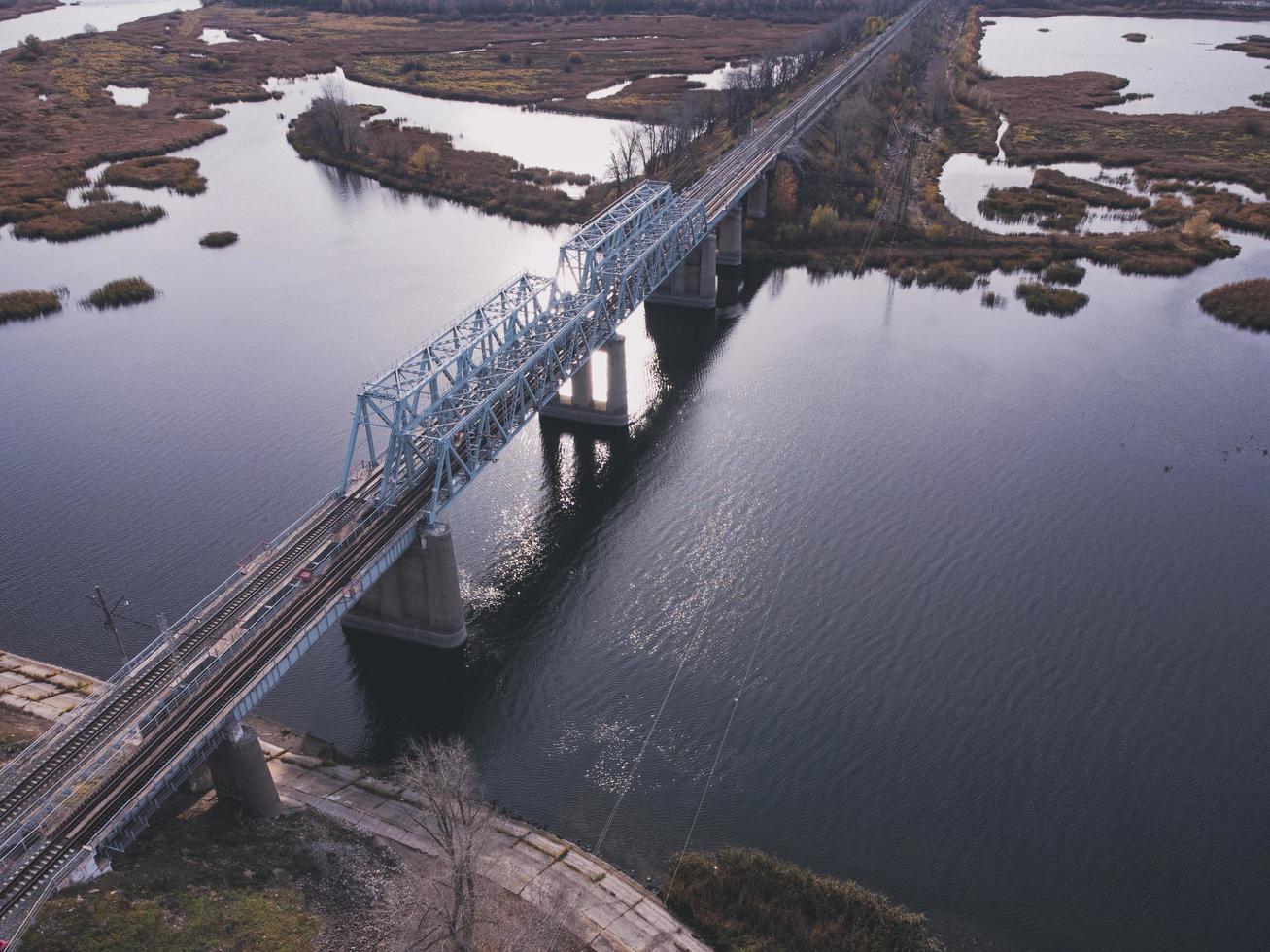 Aerial view of a body of water with a metal railway bridge on a concrete base. photo