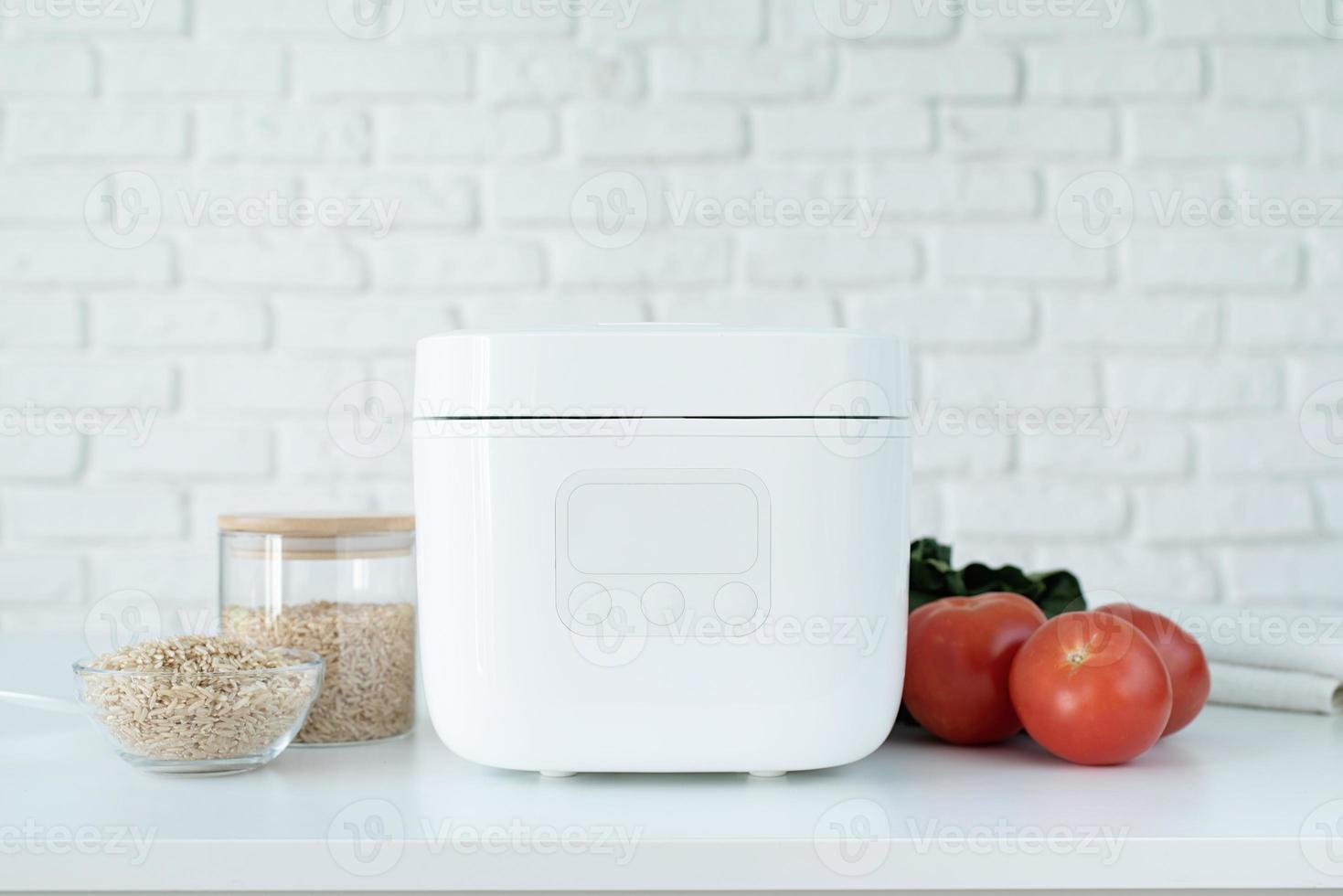 Electric rice cooker on wooden counter-top in the kitchen photo