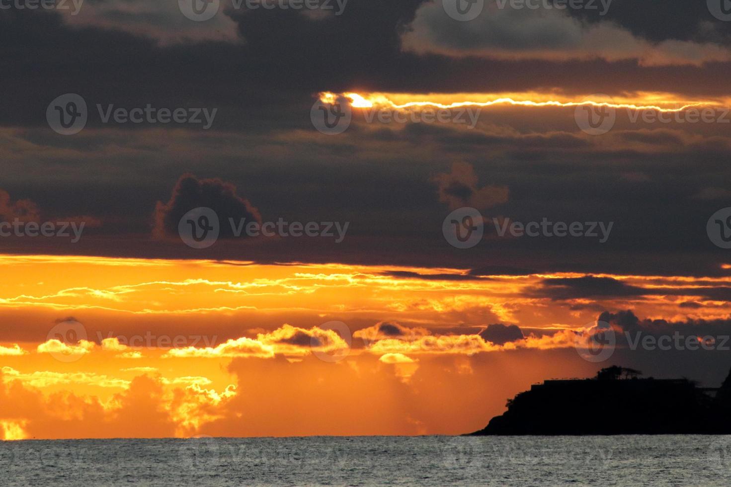Rio de Janeiro, RJ, Brazil, 2022 - People in silhouette watch the sunset at Arpoador Rock, Ipanema Beach photo