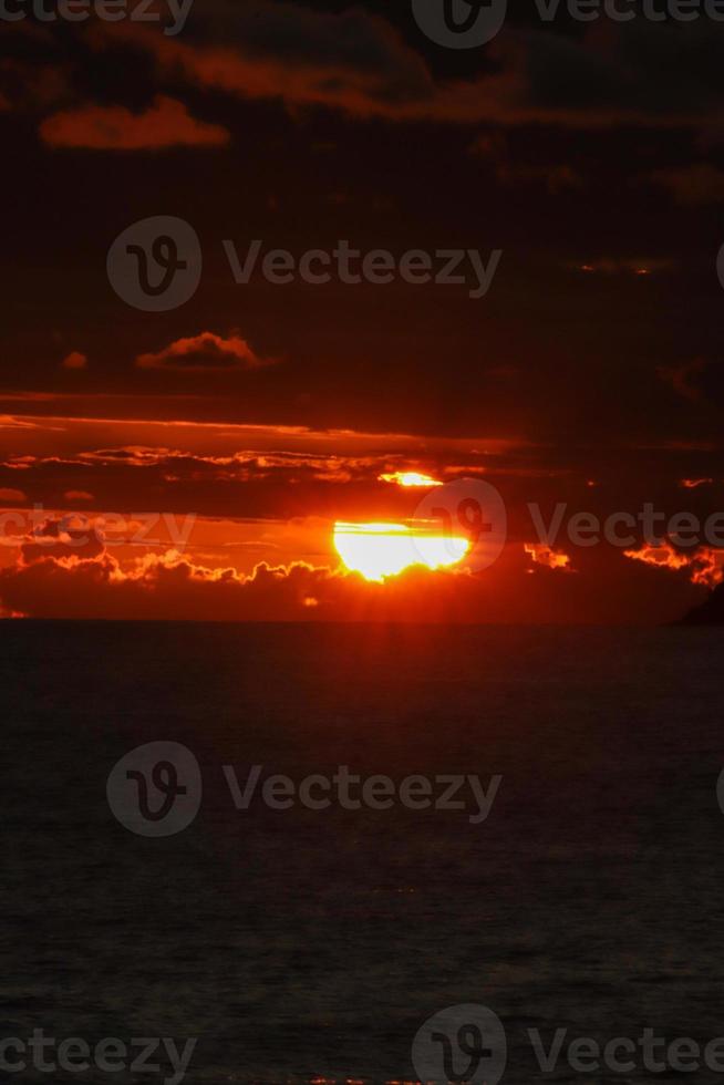 río de janeiro, rj, brasil, 2022 - personas en silueta miran la puesta de sol en arpoador rock, playa de ipanema foto