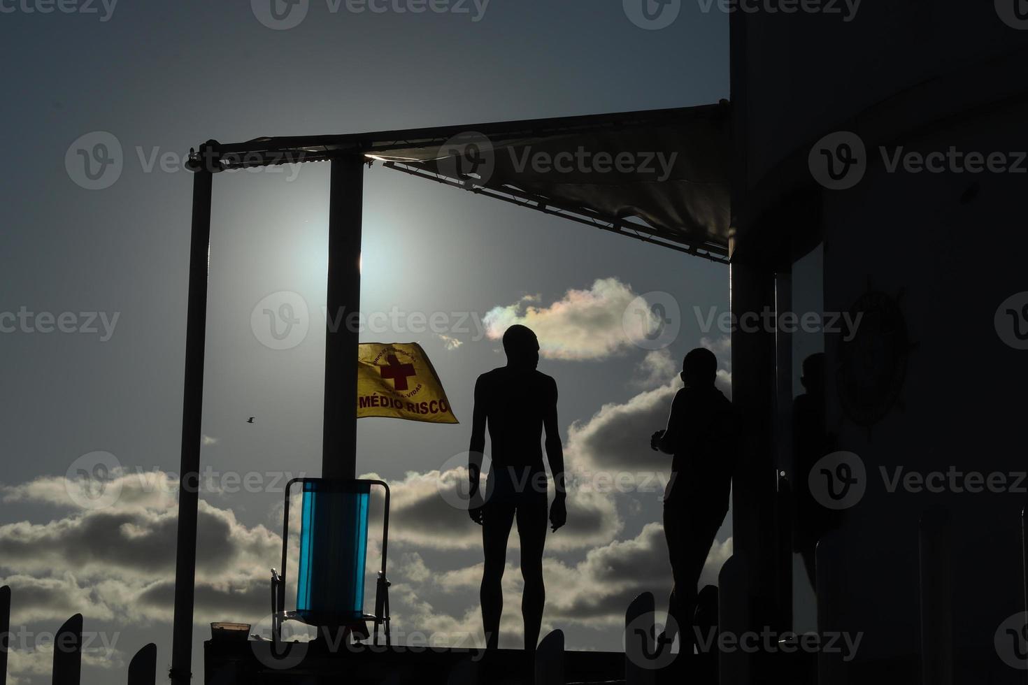 río de janeiro, rj, brasil, 2022 - personas en silueta miran la puesta de sol en arpoador rock, playa de ipanema foto