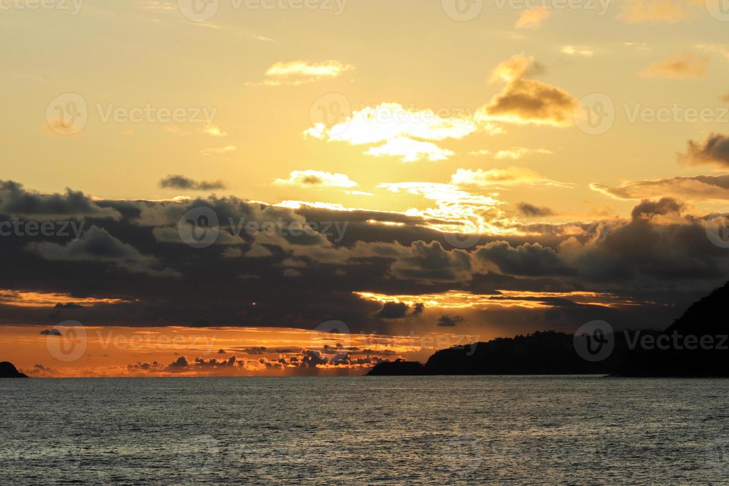 Rio de Janeiro, RJ, Brazil, 2022 - People in silhouette watch the sunset at Arpoador Rock, Ipanema Beach photo