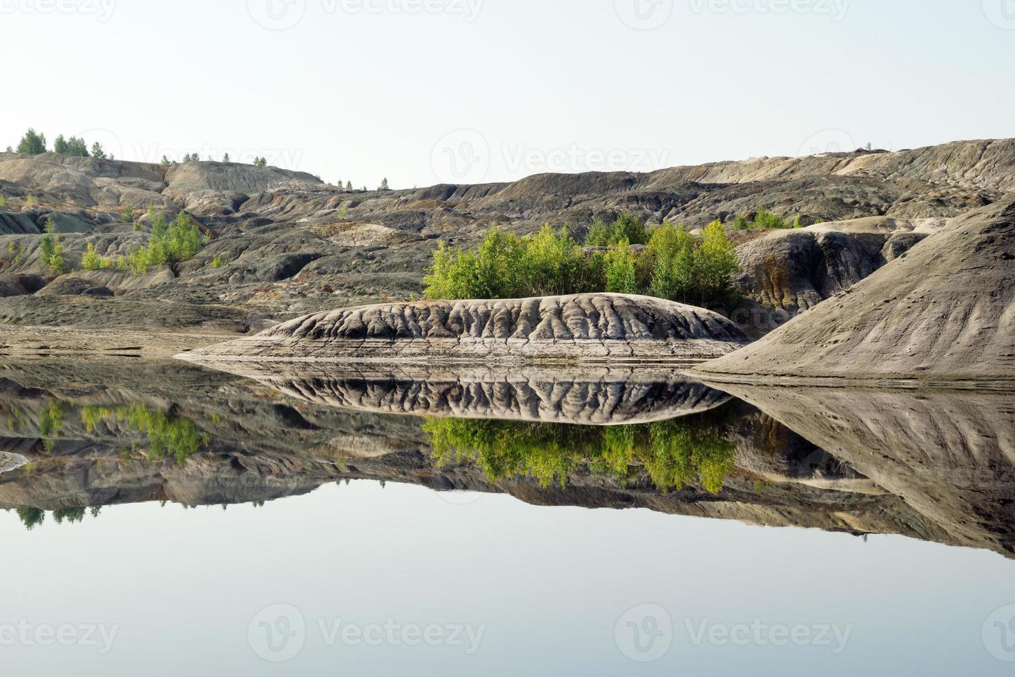 vista sobre una cantera inundada con reflejo de colinas y árboles. foto