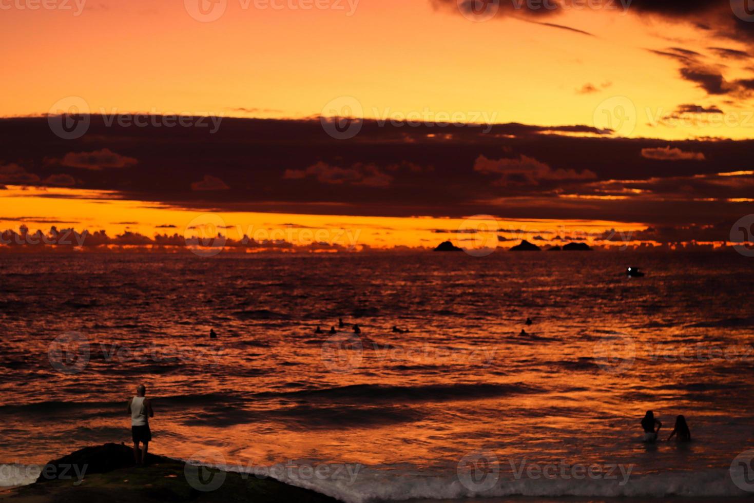 Rio de Janeiro, RJ, Brazil, 2022 - People in silhouette watch the sunset at Arpoador Rock, Ipanema Beach photo
