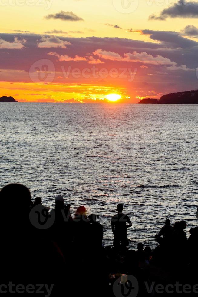 Rio de Janeiro, RJ, Brazil, 2022 - People in silhouette watch the sunset at Arpoador Rock, Ipanema Beach photo