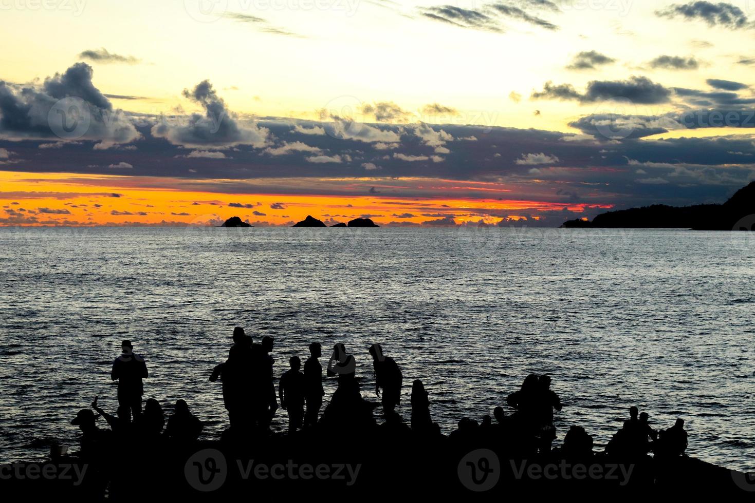 Rio de Janeiro, RJ, Brazil, 2022 - People in silhouette watch the sunset at Arpoador Rock, Ipanema Beach photo