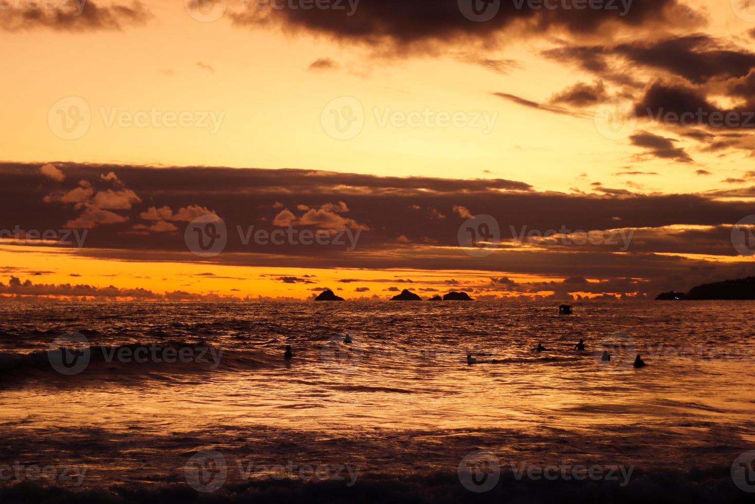 río de janeiro, rj, brasil, 2022 - personas en silueta miran la puesta de sol en arpoador rock, playa de ipanema foto