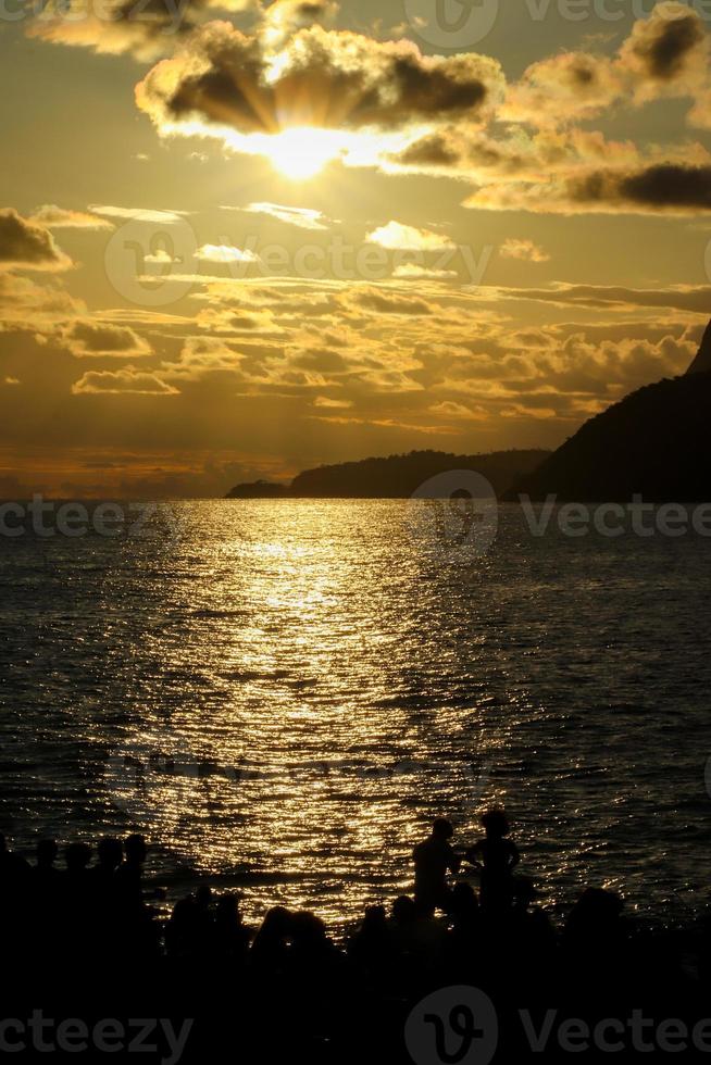 Rio de Janeiro, RJ, Brazil, 2022 - People in silhouette watch the sunset at Arpoador Rock, Ipanema Beach photo