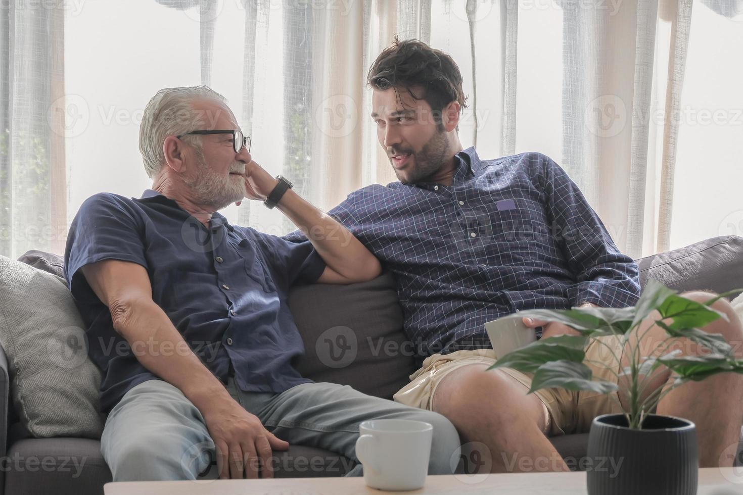 Sharing family story and authentic lifestyle concept. Two of dad and his son are relax talking in happy moment at cozy living room warmth house during holiday with coffee cup on the desk. photo