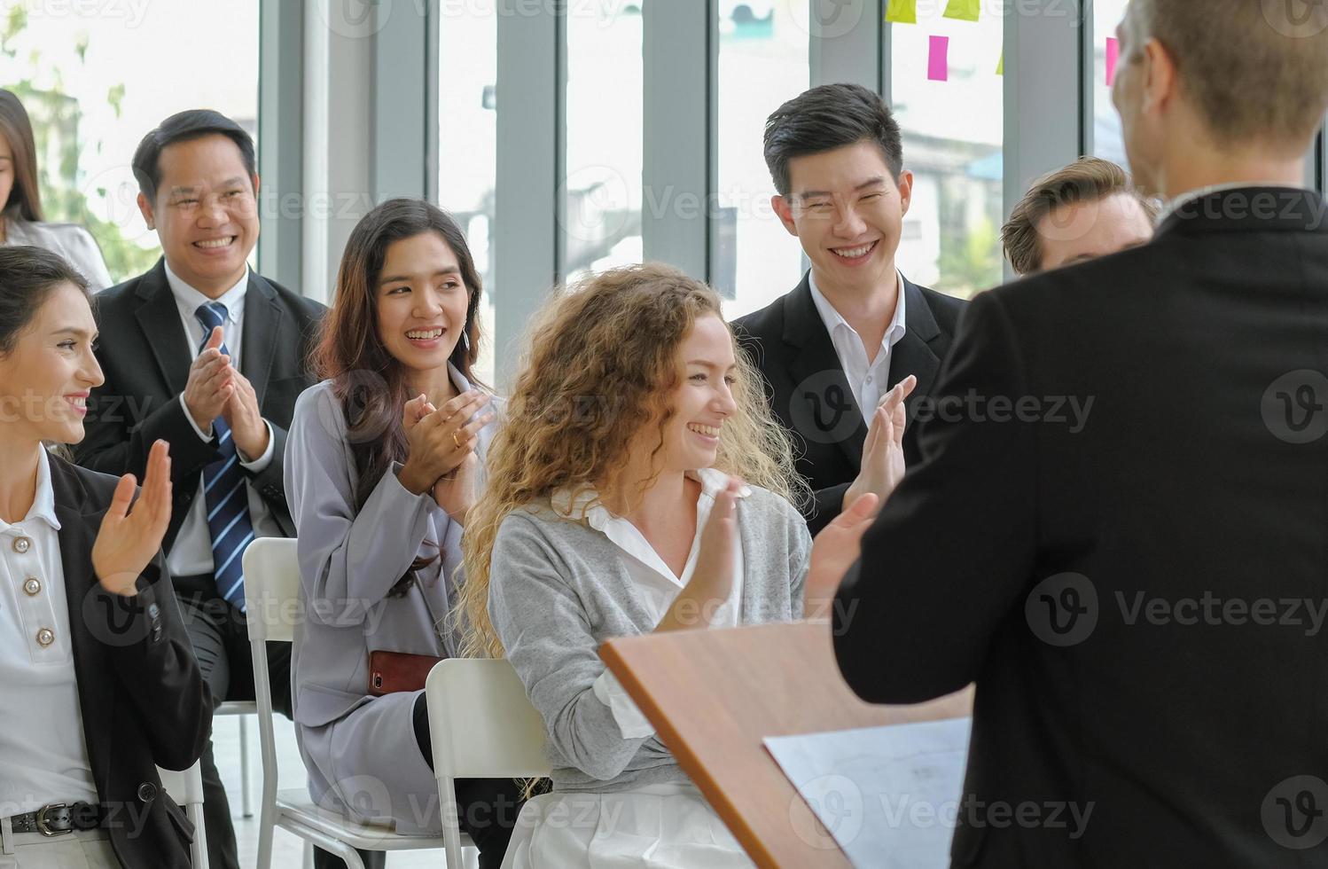 Candid business audience happy and smiley faces in seminar event. Young asian woman clapping hands together with others for congratulation to colleague at conference meeting room. Selective focus. photo