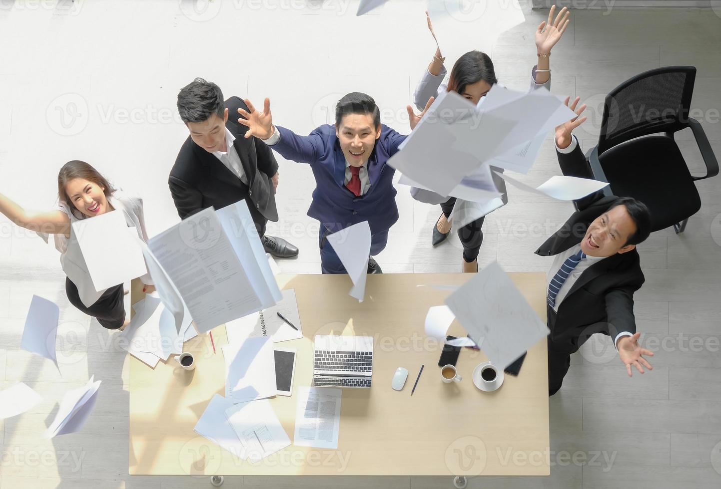 Happy asian executive business group throwing paperworks for achievement celebration at office workspace, selective focus, top view. photo