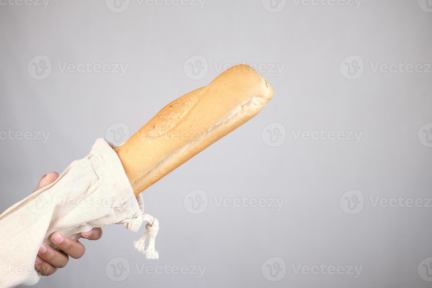holding bag with bread on white color background.. photo