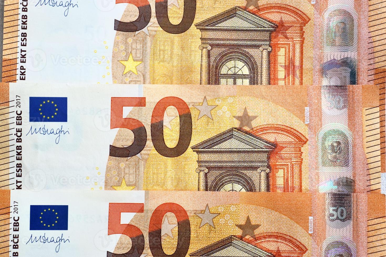 Close up of numerous euro banknotes lying on top of each other. photo