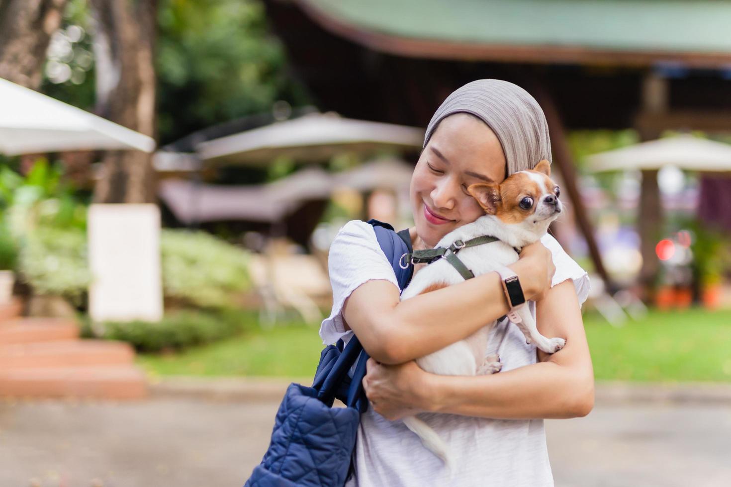 Beautiful woman holding with love Chihuahua dog in the garden outdoor. photo