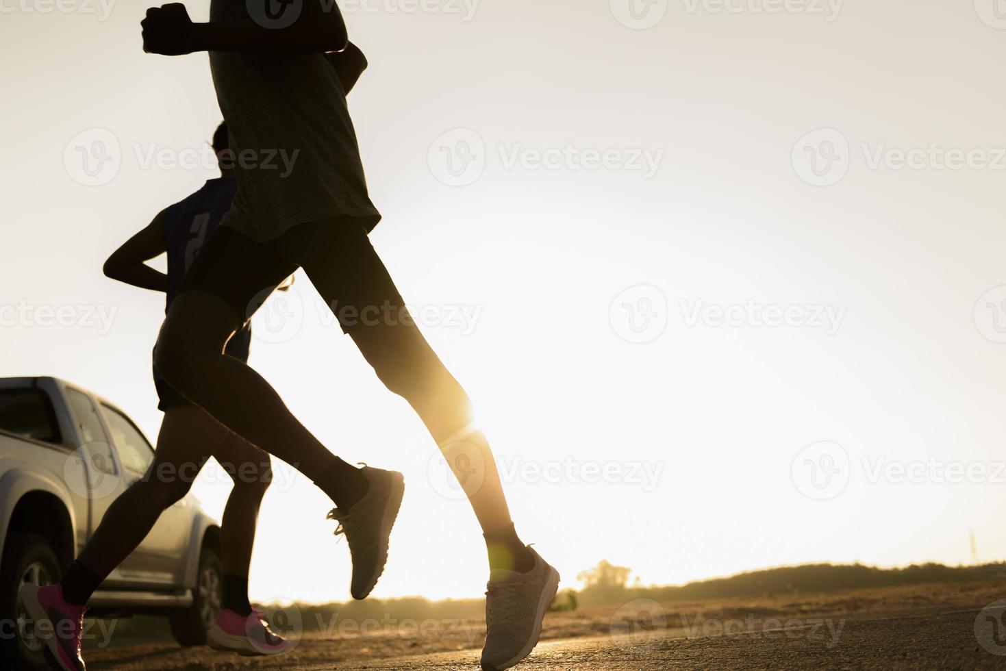 A man running on the asphalt road at sunset photo