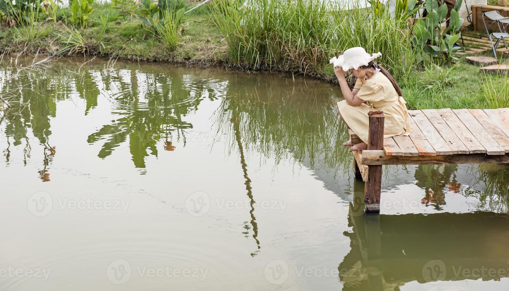 side view of the girl alone on the bridge The child is unhappy, feels pressured, thinks about the child's problems. The concept of depression in adolescence. photo