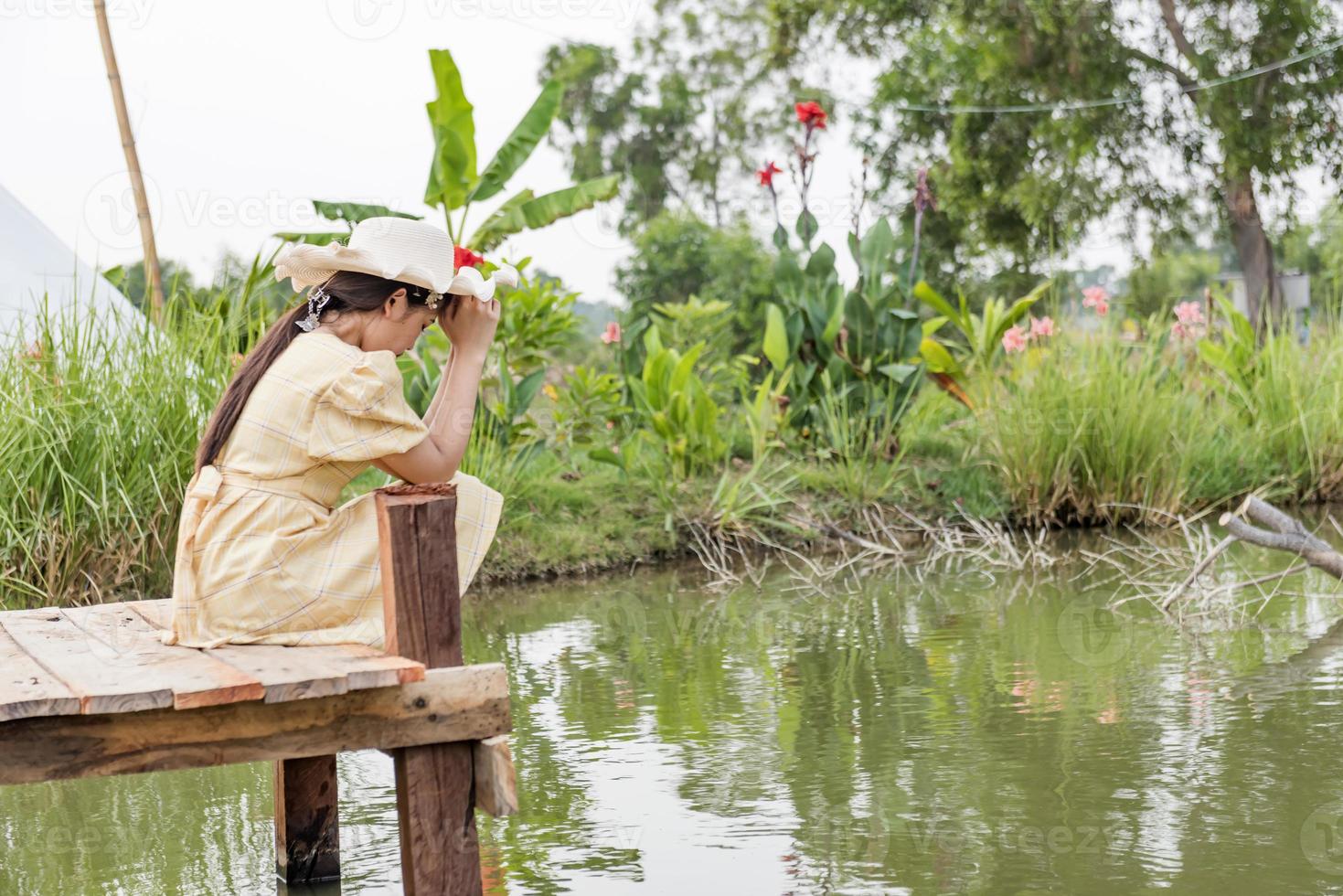 side view of the girl alone on the bridge The child is unhappy, feels pressured, thinks about the child's problems. The concept of depression in adolescence. photo