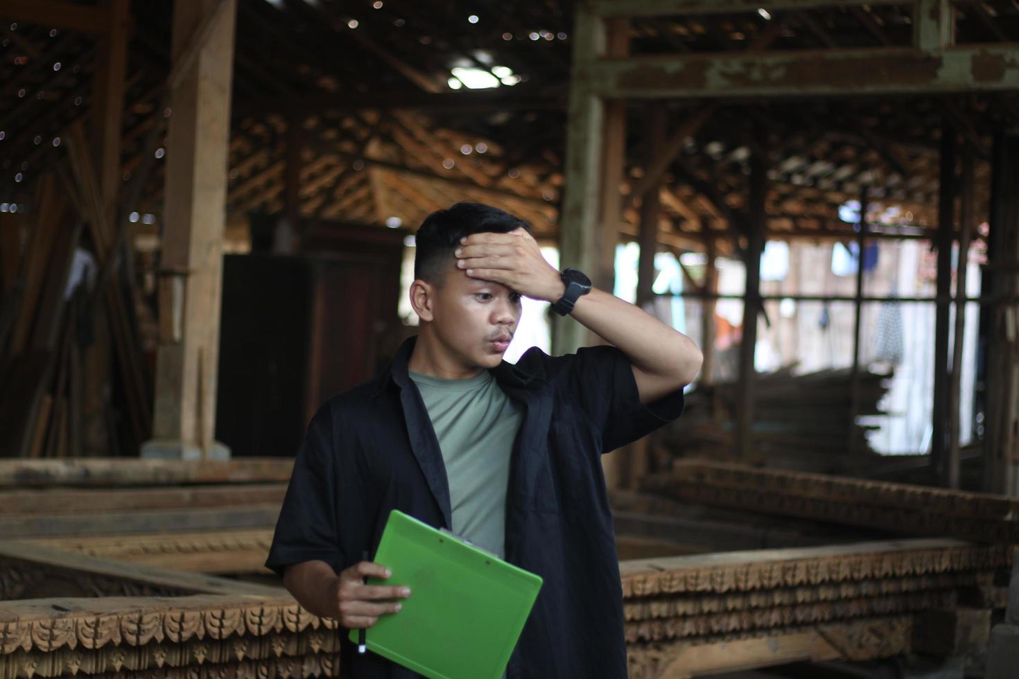 ASIAN YOUNG MAN BOSS OF WOOD COMPANY CONFUSED CHECKING QUALITY photo
