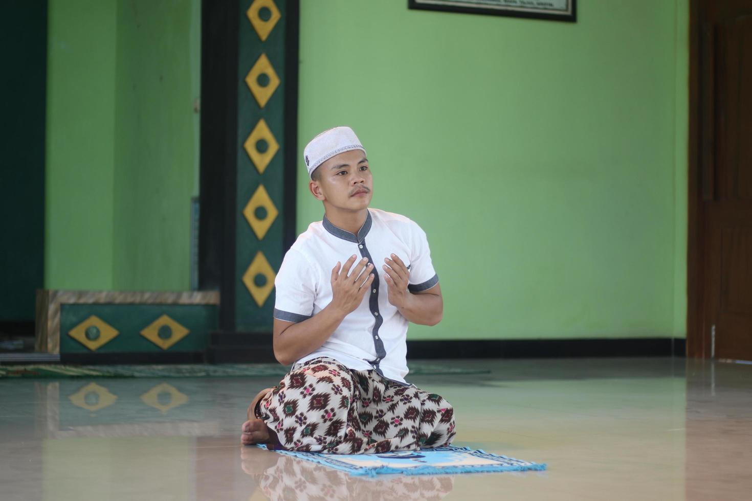 Young asian muslim praying in the mosque photo