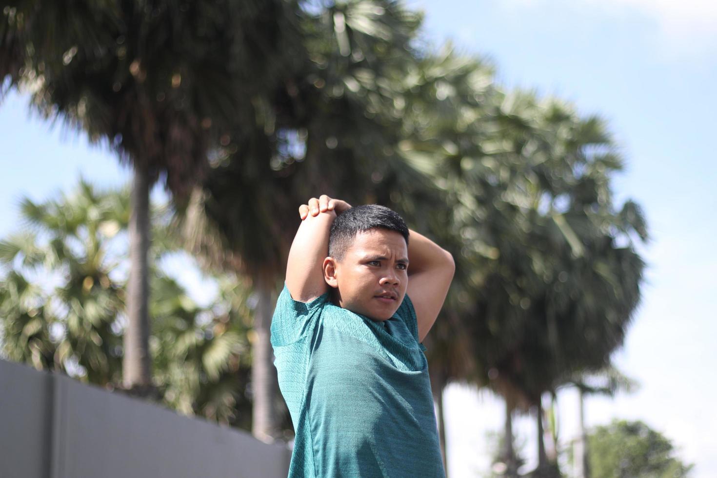 Young asian boy warming up for jogging in the morning photo