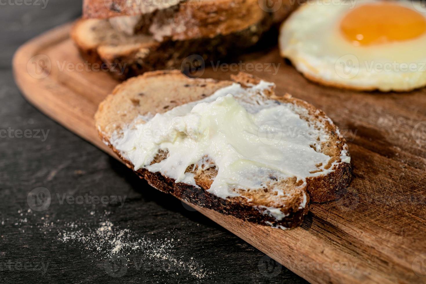 Breakfast food fried egg bread slice in cutting board. photo