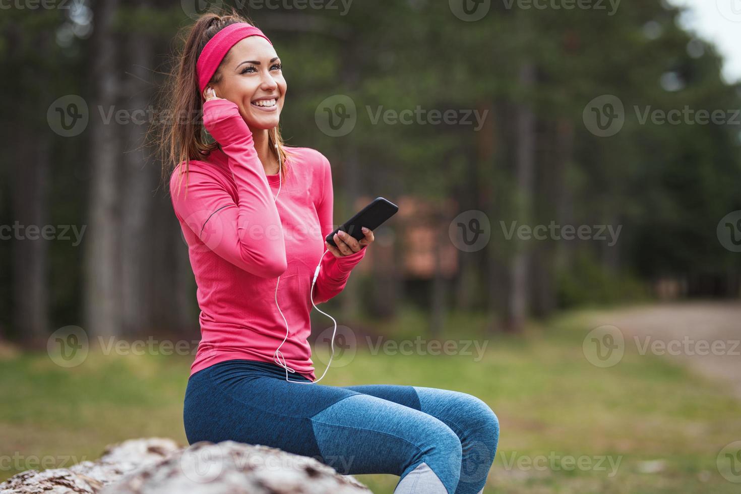 mujer joven descansando después de trotar foto