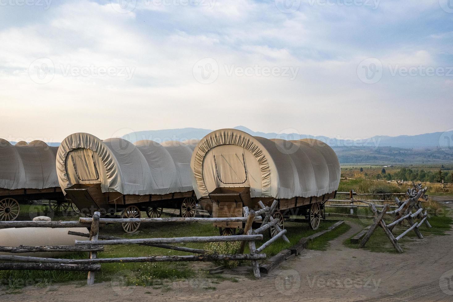 Covered wagons in yard at ranch in Yellowstone park with sky in background photo