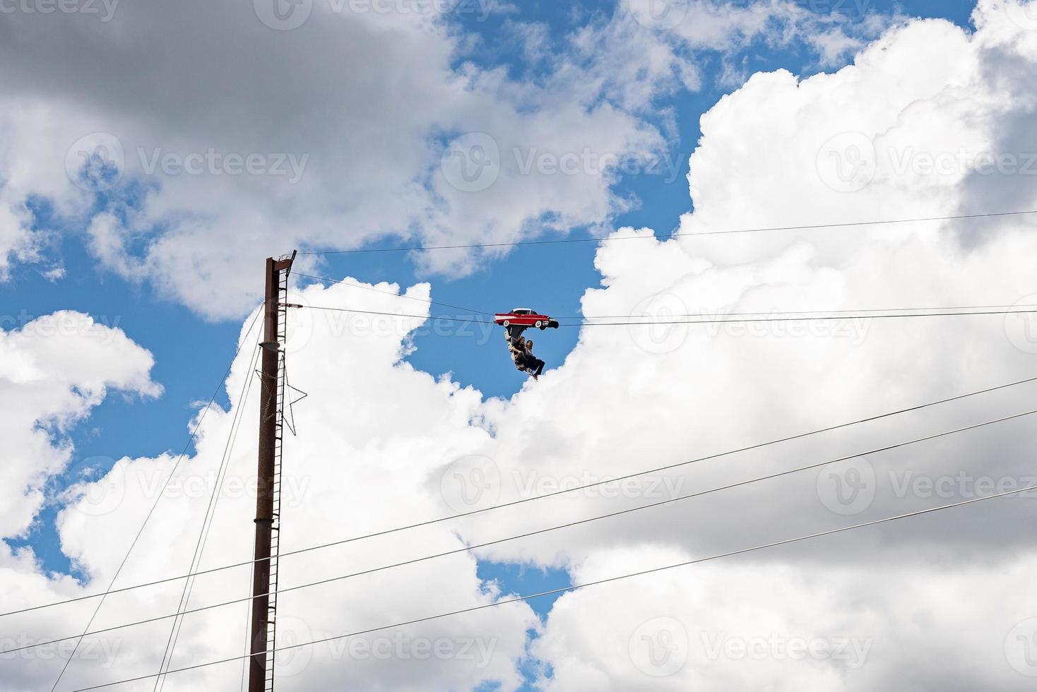 Tourists enjoying unique ride high up with cloudy sky in background photo