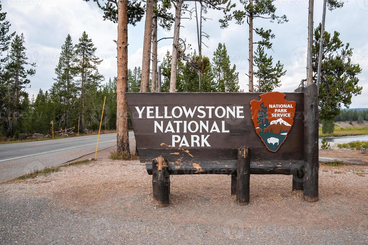 Signboard at entrance against trees at famous Yellowstone National Park photo