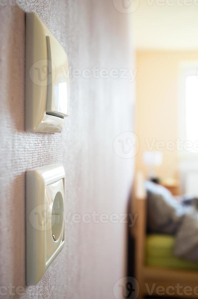 light switch and electrical outlet hanging on the wall of the living room photo