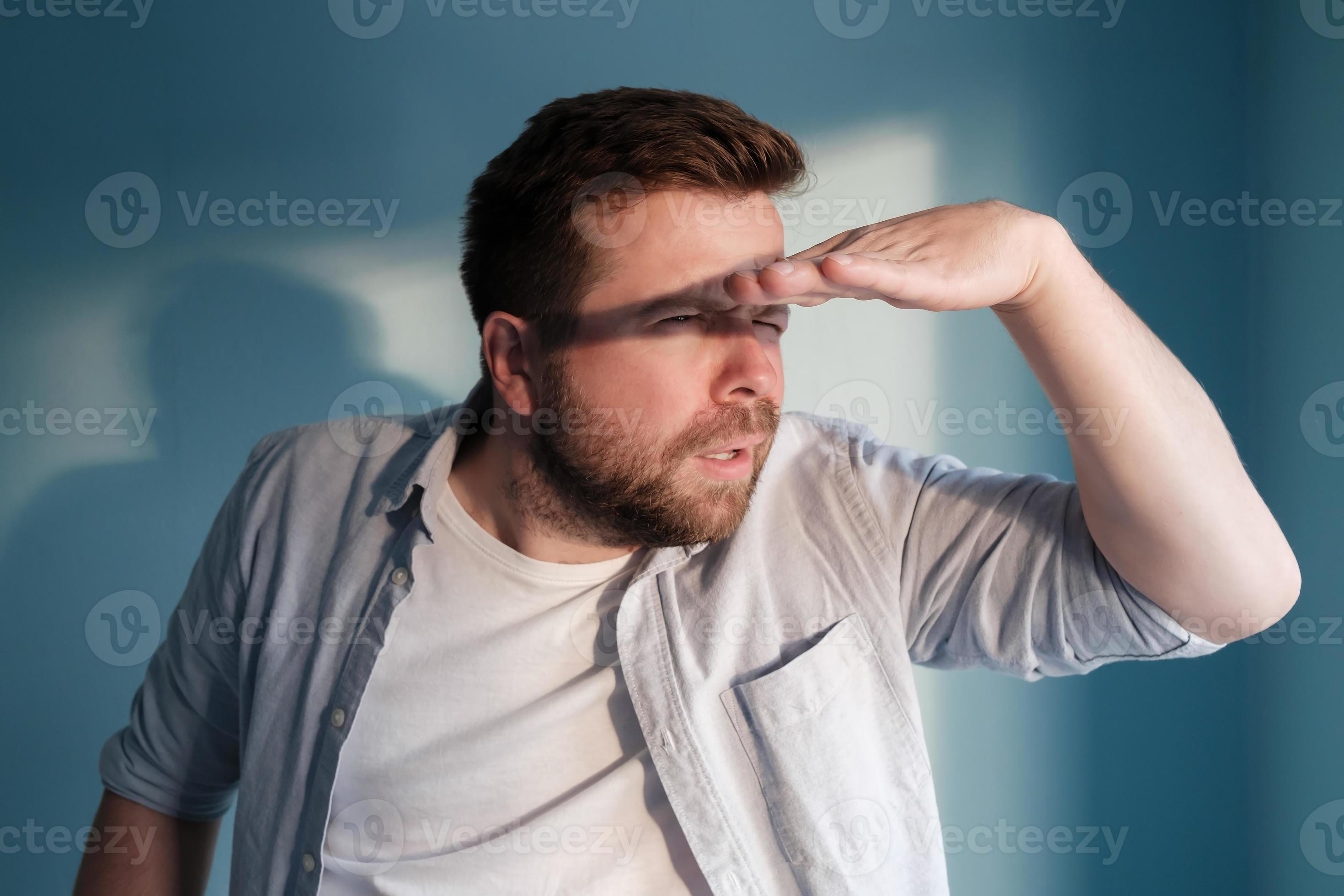 Concentrated man is trying to see something in the distance, hiding Concentrated man is trying to see something in the distance, hiding